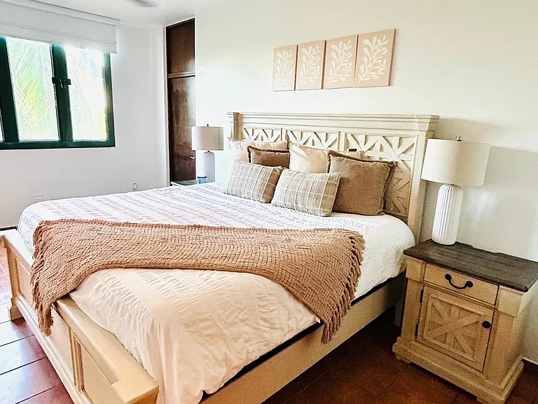Comfortable master bedroom equipped with a ceiling fan, A/C, blinds, full closet, nightstand, bedside lamp, and a private en-suite bathroom.