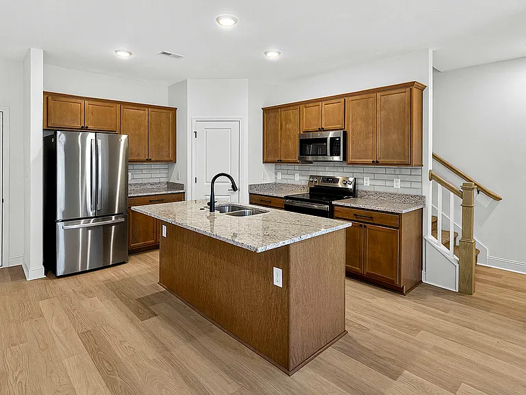 Stainless appliances and center island with breakfast bar