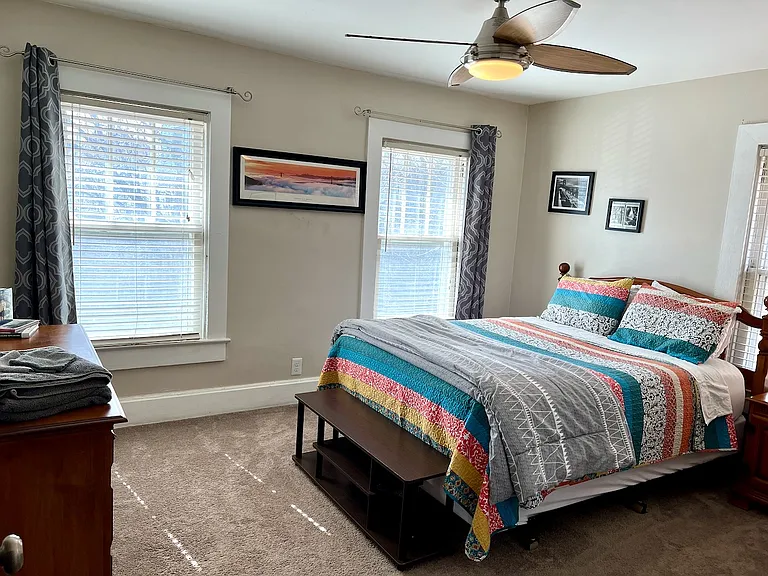 Primary bedroom, queen bed, two dressers and blackout curtains and blinds.