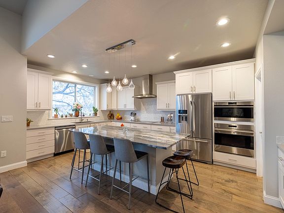 Kitchen with front range mountain view, with Wolf induction stove, steam oven, beautiful dolomite countertop, coffee/liquor bar, walk-in pantry.