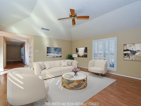 As you enter through double front doors, to your left you are welcomed into an oversized light and bright living area with a tray ceiling and where Planation shutters grace the double paned windows.