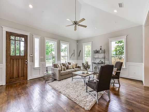 Walls of windows allow natural light into this space showing off the gleaming hardwoods that continue throughout the home.