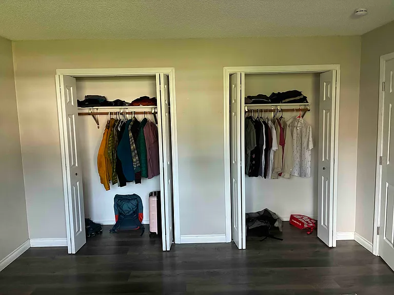 Double closet that extends the entire length of that wall.
