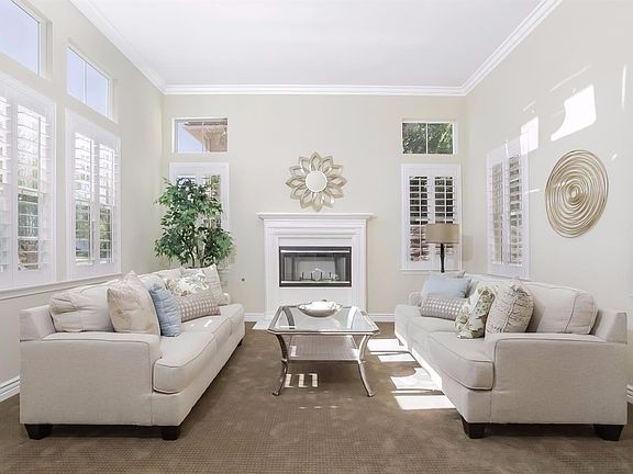 Elegant formal living room with fireplace. Base and Crown moldings. Newer neutral carpeting.