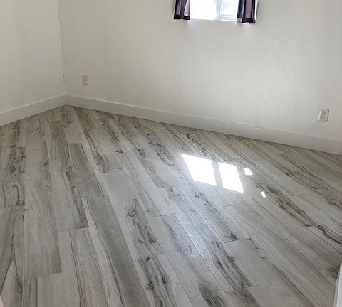 Master bedroom with King Size bed and two end tables with ceiling fan.