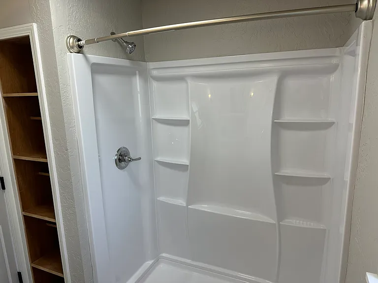 Primary Bathroom shower with ample shelving