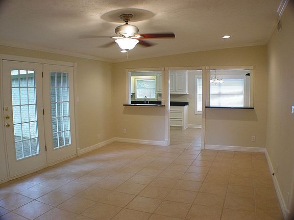 Den features tile floors and french doors opening onto the deck.
