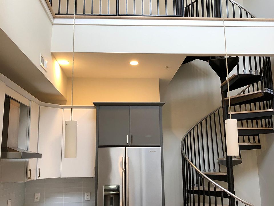 Sleek spiral staircase from main floor to second-floor loft and private roof deck.