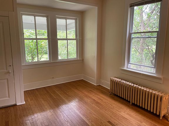 Large living/dining room - dining area facing the front of the building with woods and garden views.