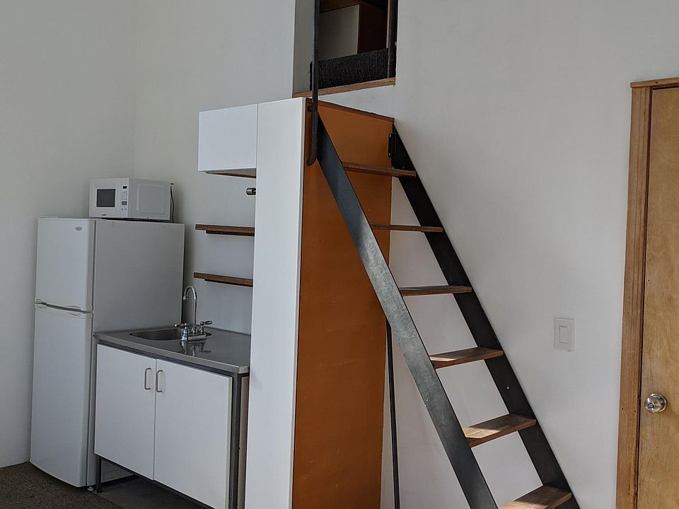 Kitchen area, no stove. Stairs lead to bedroom and bathroom