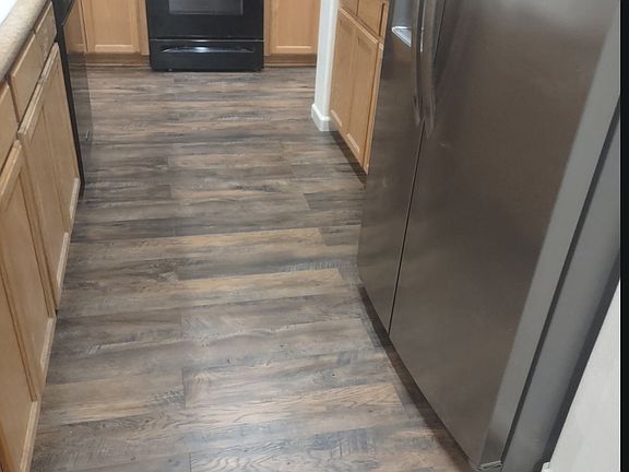 Kitchen has a gas stove, refrigerator, island with room for seating and a kitchen nook