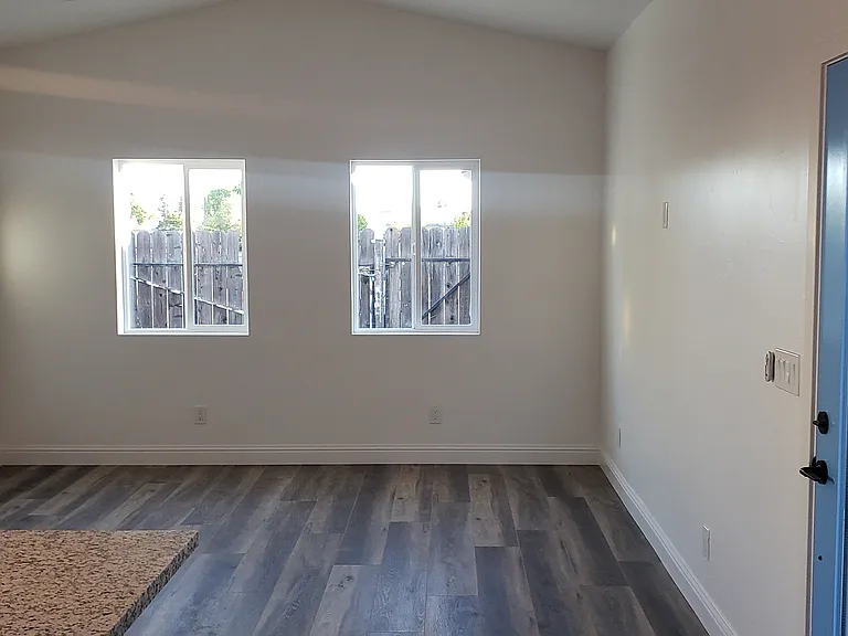Living Room area with eye-height wall outlet (right side) to hang television unit on wall.