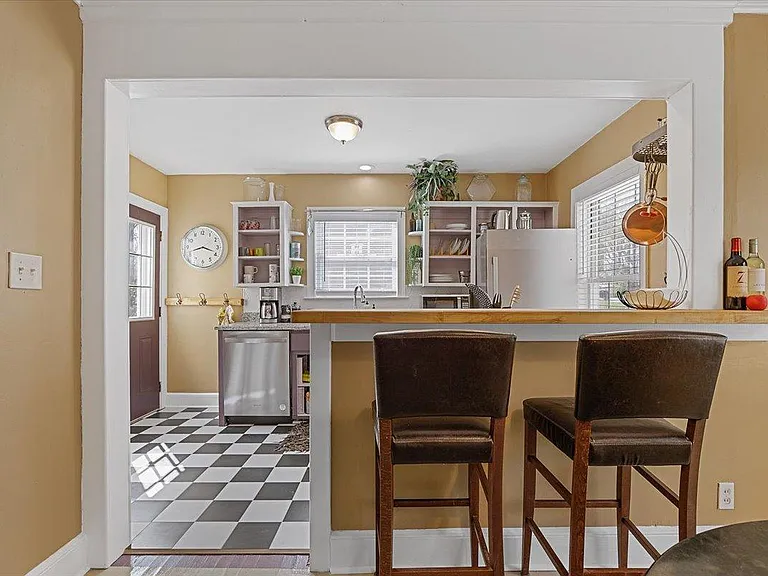 Dining room at Hunsucker's Place features a piano and a view into the kitchen. Located within walking distance of Cone Health Hospital and Downtown Greensboro, this space is perfect for enjoying meals and music in a cozy, central location.