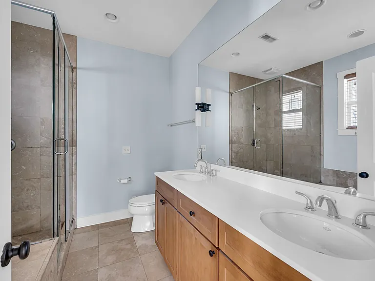 primary bathroom with dual vanity, walk in shower and whirlpool tub