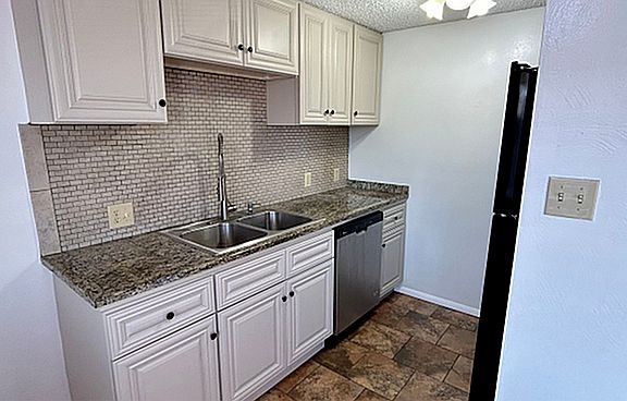 Charming kitchen with modern amenities, featuring sleek countertops, stainless steel appliances, and ample cabinet space in a 1 bed, 1 bath apartment for $1,250/month.