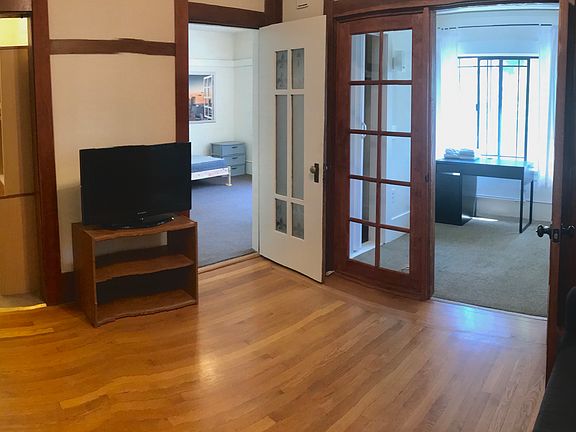 Livingroom with door open to smaller bedroom on the right,and door open to larger bedroom in the middle