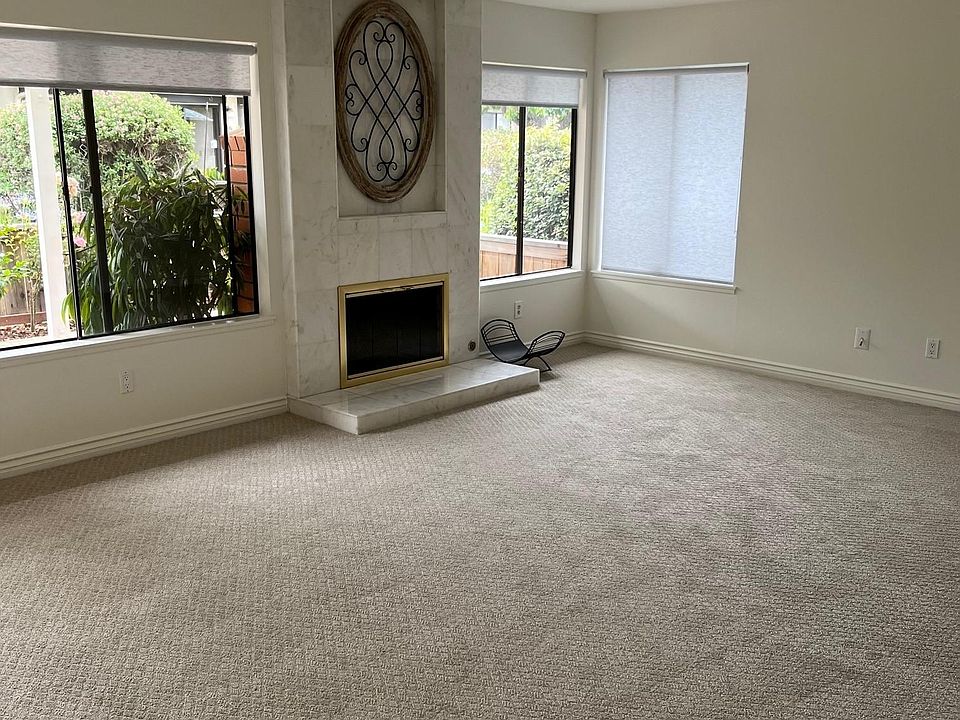 Living area with fireplace and view of greenbelt.