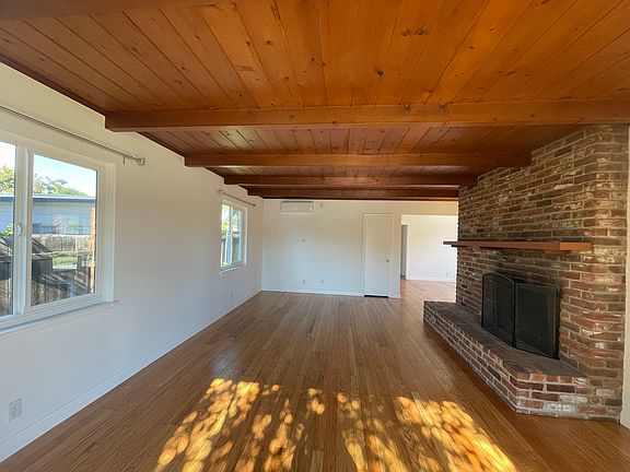 Living room with new windows, new interior paint, freshly refinished hardwood floor & new mini split