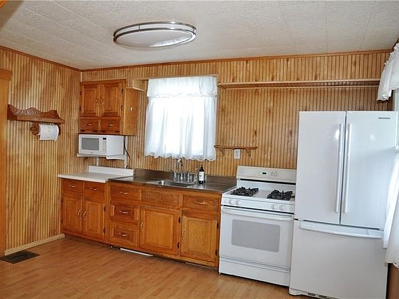 Kitchen has plenty of natural wood cabinets for storage and counter space to prepare delicious family meals.