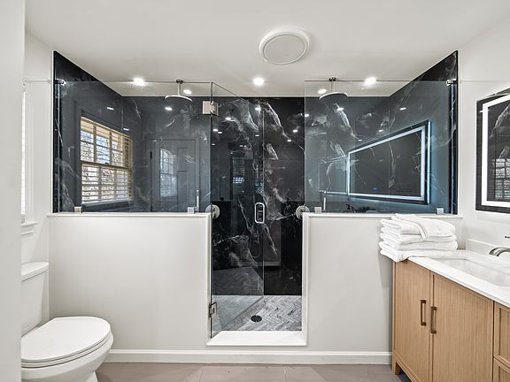 Indulge in spa-like luxury in your private ensuite retreat_featuring dual rain shower heads, a sleek frameless glass enclosure, an LED vanity mirror, and a Bluetooth fan to set the perfect mood. Modern comfort meets effortless elegance.