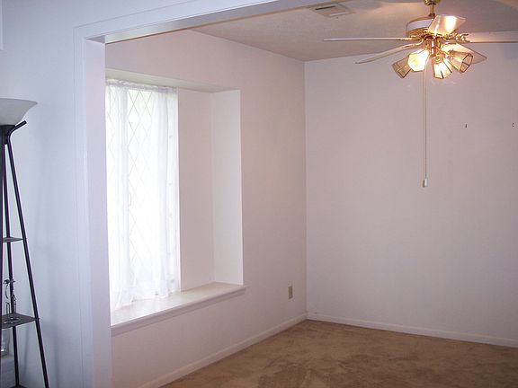 Formal living looking into formal dining, both rooms have leaded glass windows