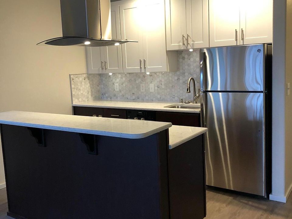 Main kitchen and Island. Quartz countertops and island hood with ample lighting and venting