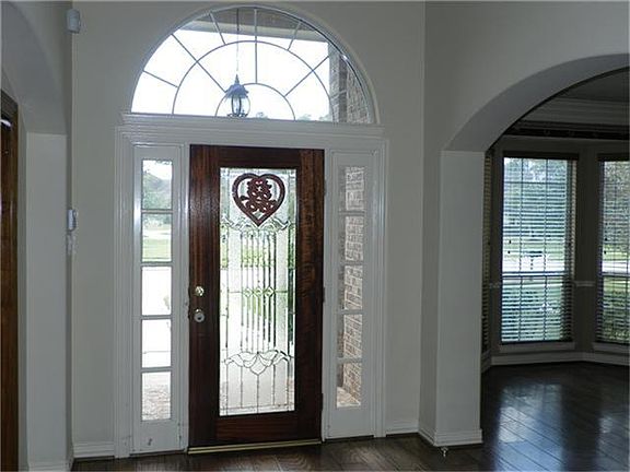 Beautiful front entry door features lead glass.  A large arched entry leads to the formal dining room and on the other side is a study w/glass french doors.