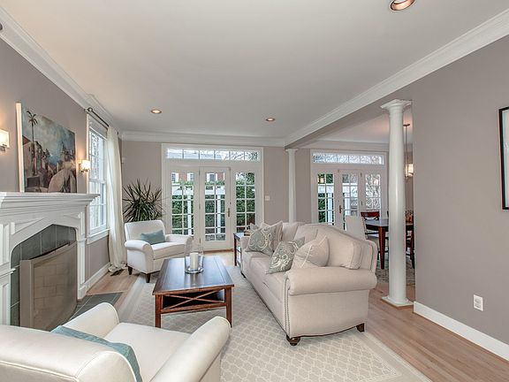 Open living room w/ FP & French doors to patio