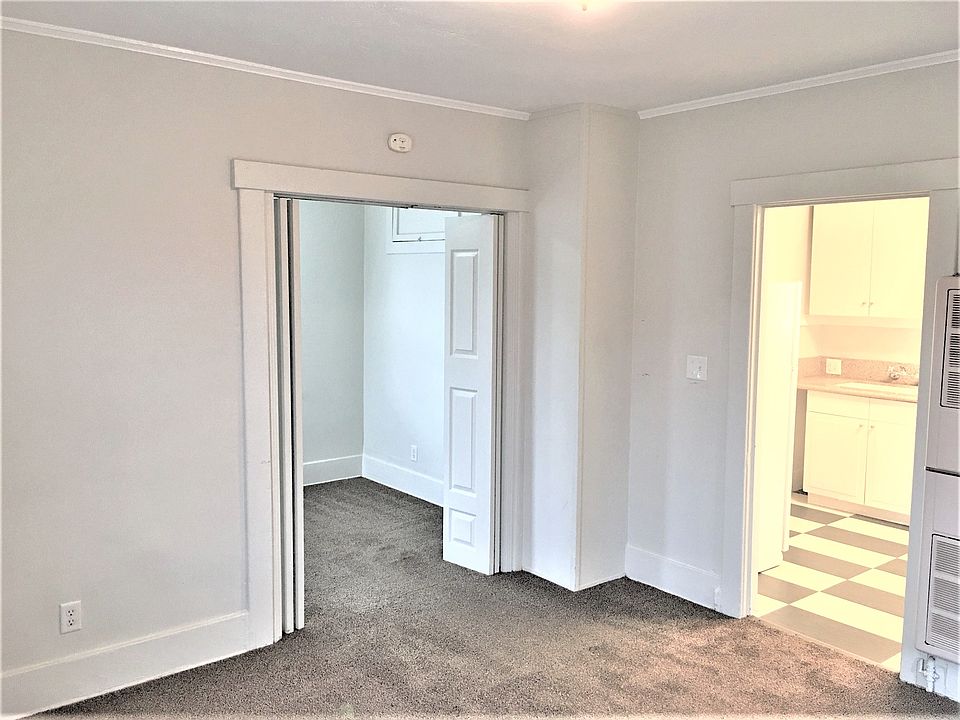 Living room looking into bedroom (left) and kitchen (right)