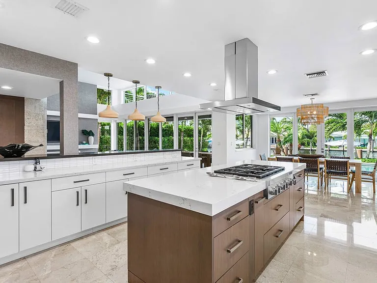 Quartz countertops, a spacious island, and elegant pendant lighting.