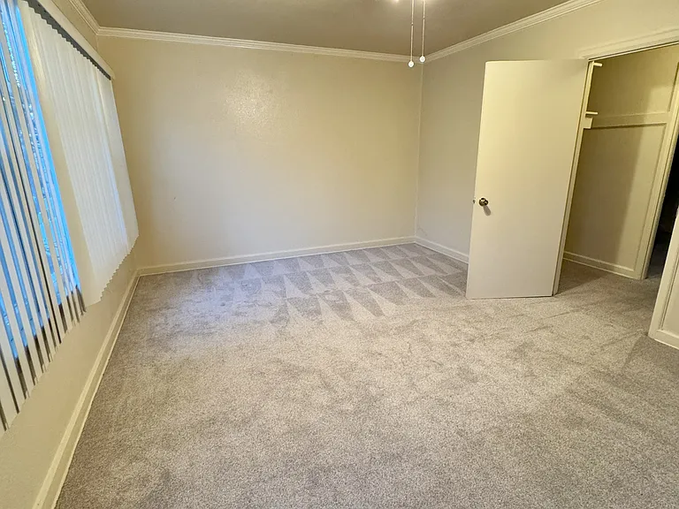 Living Room, with vertical blinds and entry to Bedroom Area