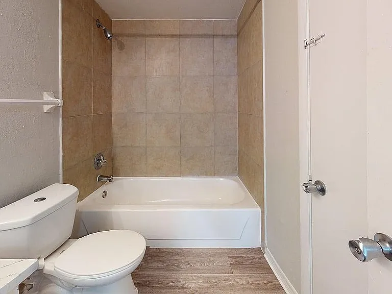 Modern bathroom featuring a sleek bathtub, elegant tiling, and contemporary fixtures.