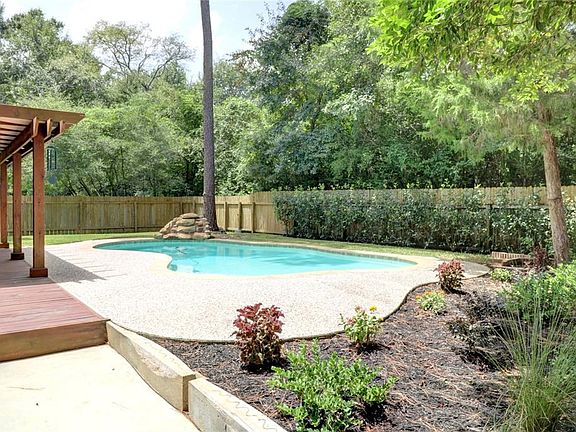 Backyard with pool with waterfall and pergola.  Perfect for outdoor entertaining.