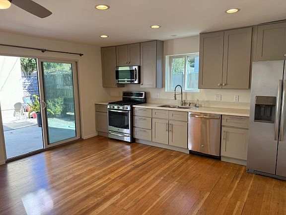Living area, kitchen with view toward patio.