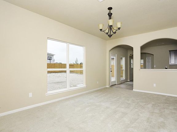 Formal dining opens up to the kitchen. Decorative light fixtures and lots of windows!