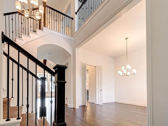 As you walk into the home you are greeted by this grandiose 2-story soaring staircase with ornate wrought iron spindles and oak posts.