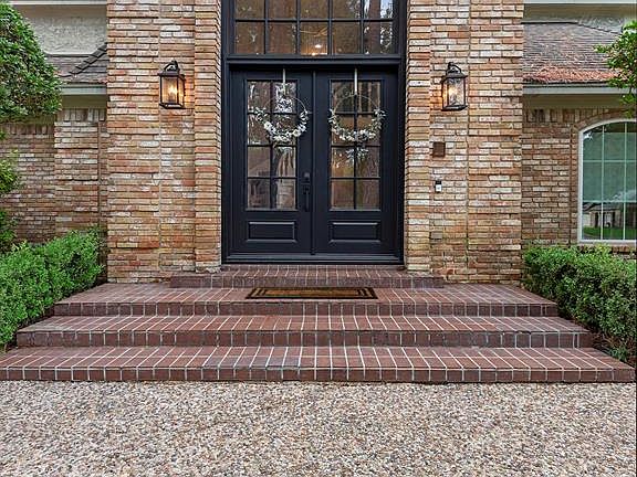 Make a grand entrance with elegant iron double doors with in-laid glass and a gorgeous arched glass window above.