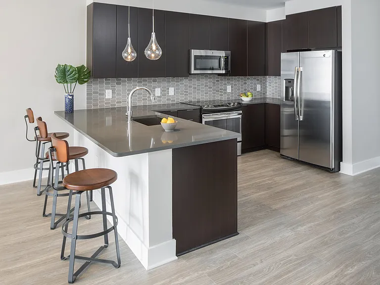 Gourmet kitchens with quartz countertops and backsplashes, modern light fixtures and stainless-steel appliances