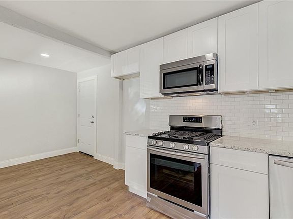 The backdoor is off the kitchen, with extra space for a table, storage, etc.