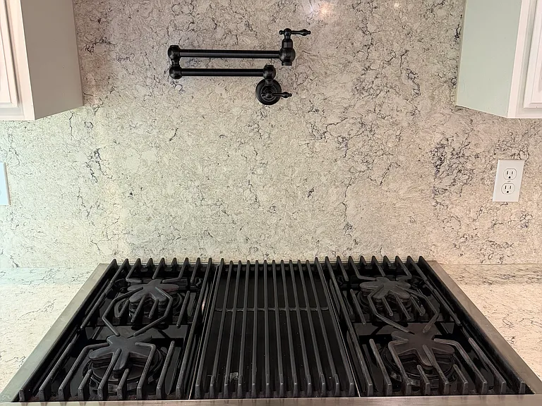 Thermador gas cooktop with stainless steel hood with heat lamps; beautiful pot filler to easily fill stock pots