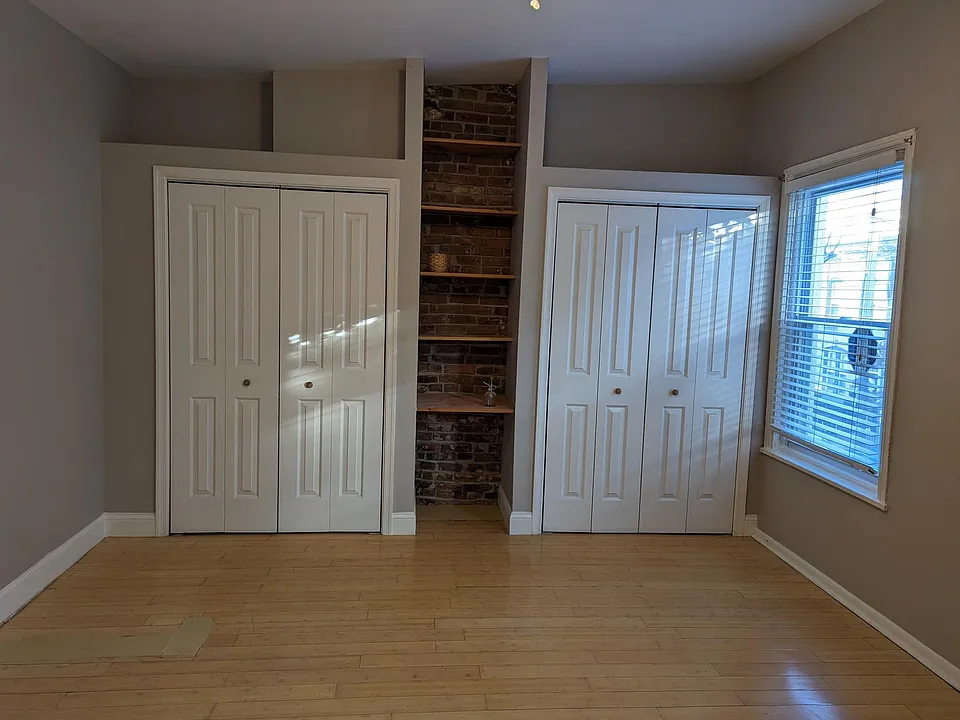 Front room with double closets, desk and shelves between closets.