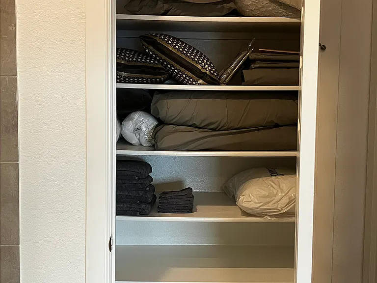 linen closet in primary en-suite bath