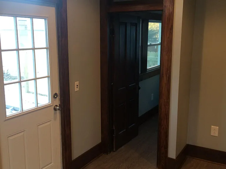 standing in the back porch / play room, the back door to patio on the left, 1/2 bath and laundry room straight ahead