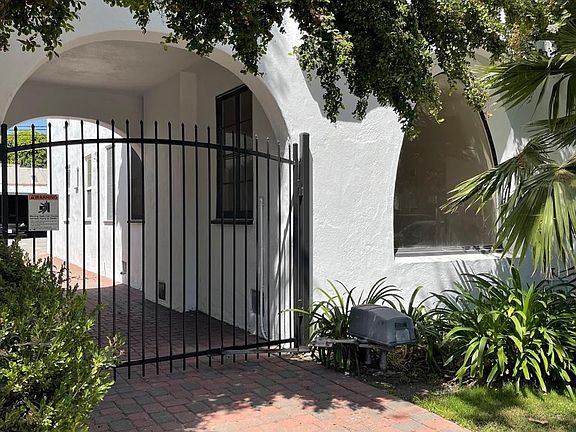 Privacy gate leads to a covered 2 car carport with EV hook up