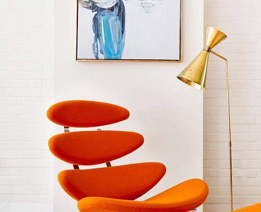 Eye catching orange Corona Chair by Poul Vilter creates a cool reading space.