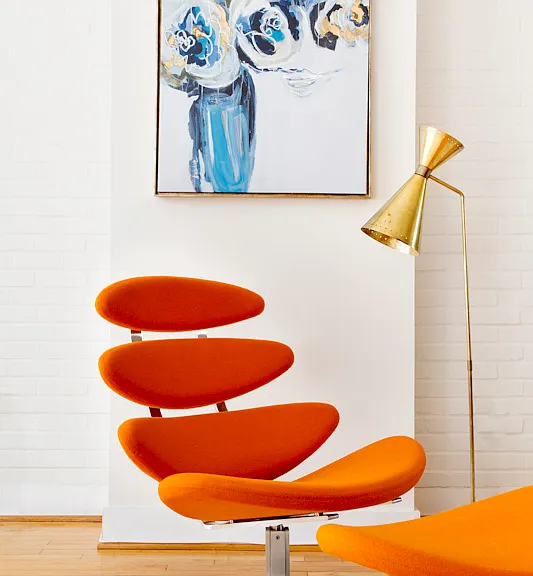 Eye catching orange Corona Chair by Poul Vilter creates a cool reading space.