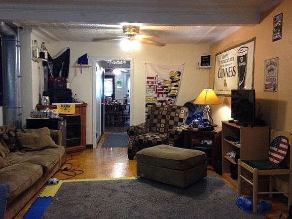 which is Huge with a Functional Gas FirePlace, Two Ceiling Fans, Original Tin Ceiling & Wall Length Barber Shop Mirror, all looking into the Kitchen and Rear Door to CourtYard