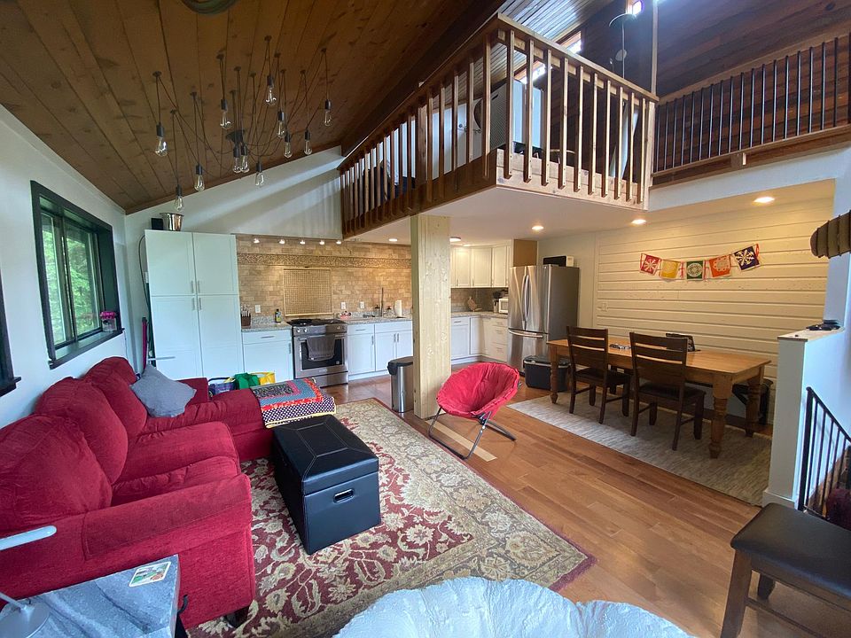 2nd floor, open floor plan with windows looking into the trees and porch with mountain views.
