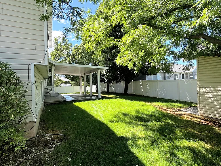 View of back yard with covered patio.