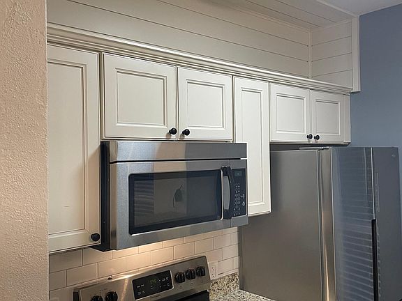 Extra Display storage. Glass top Stove. Microwave. Subway Tile backsplash.